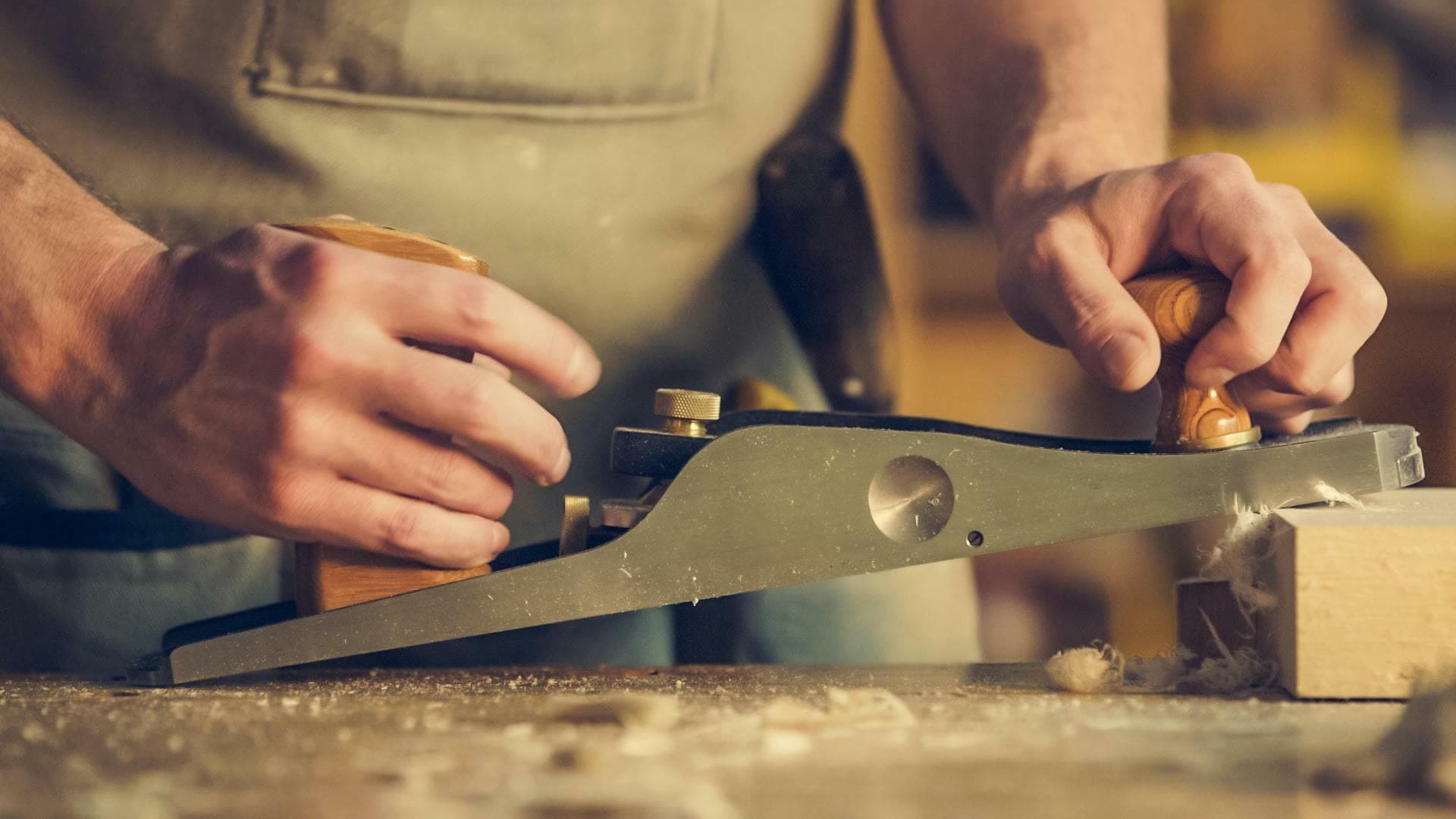 Close-up of a hand plane being used to finish a piece of timber
